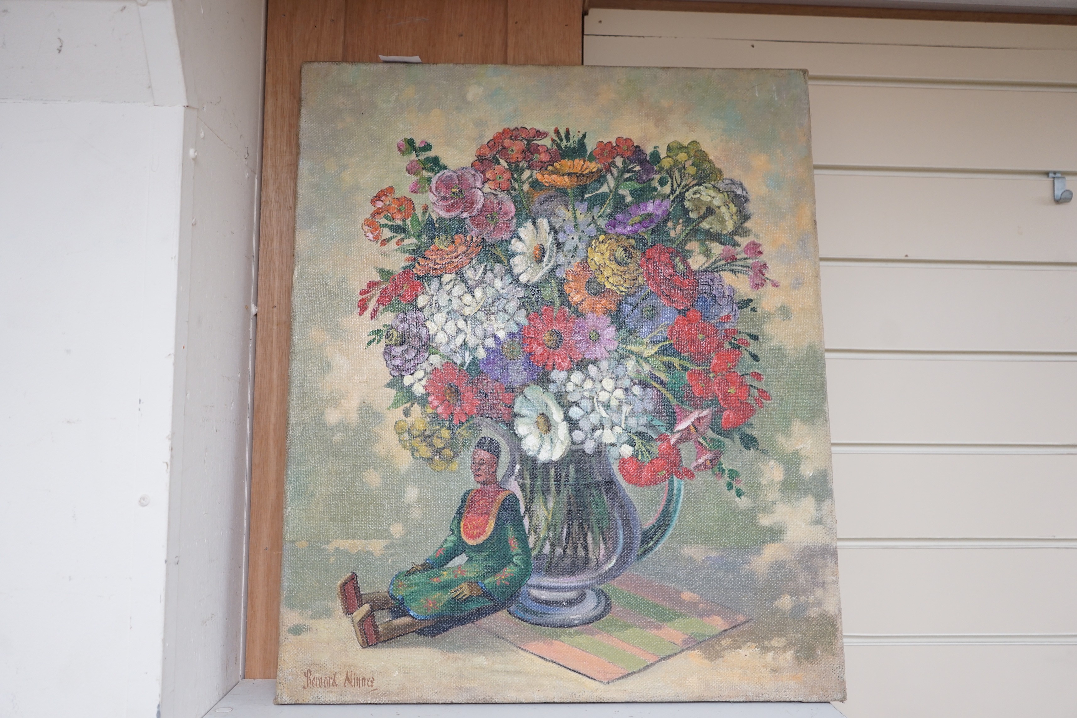Bernard Ninnes (1899-1971), oil on canvas, Still life with Indonesian doll beside a vase of flowers, signed, 60 x 51cm, unframed